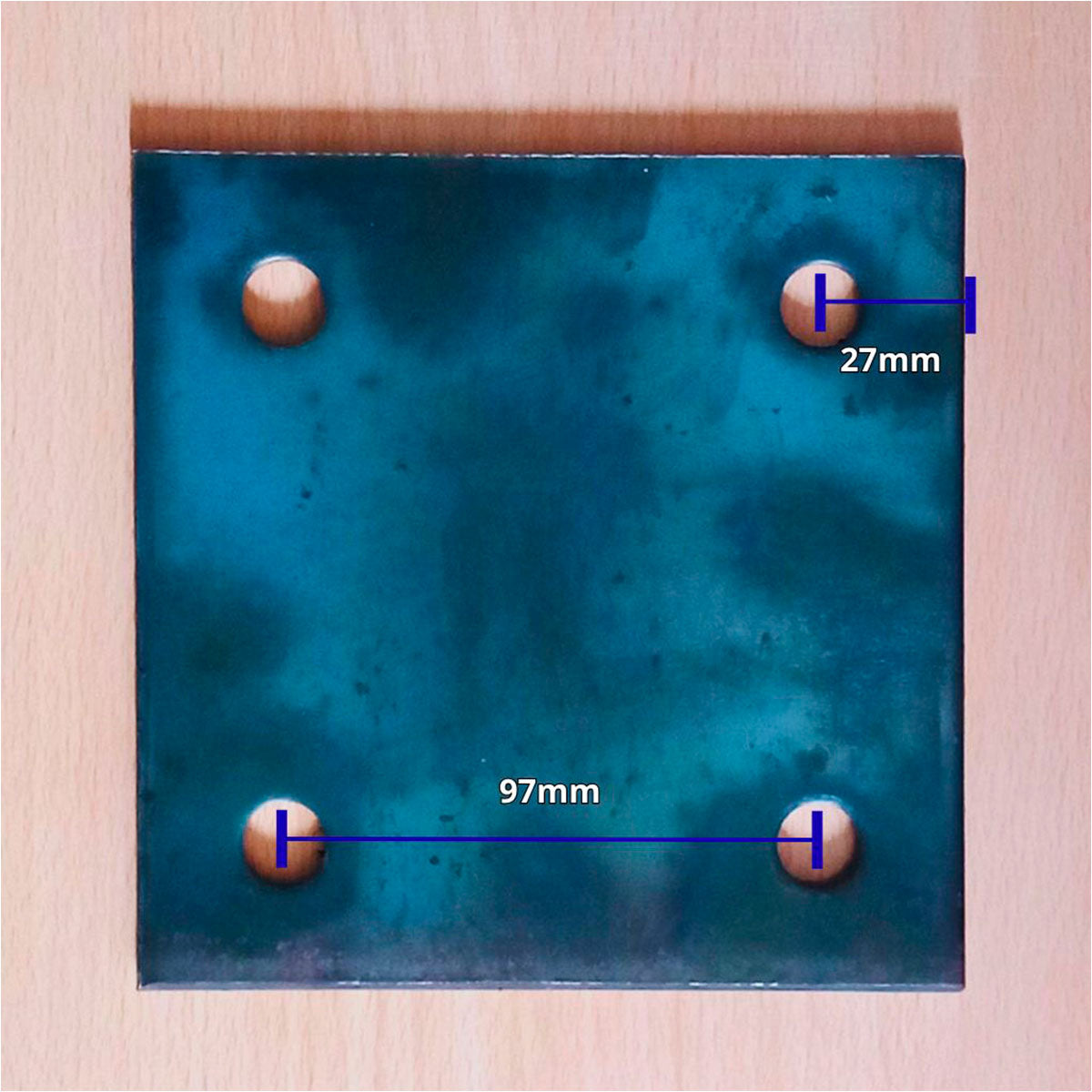 Flanche 15x15x6mm mostrando medidas internas de orificio a orificio de 97mm y desde uno de los huecos hasta la orilla de 27mm
