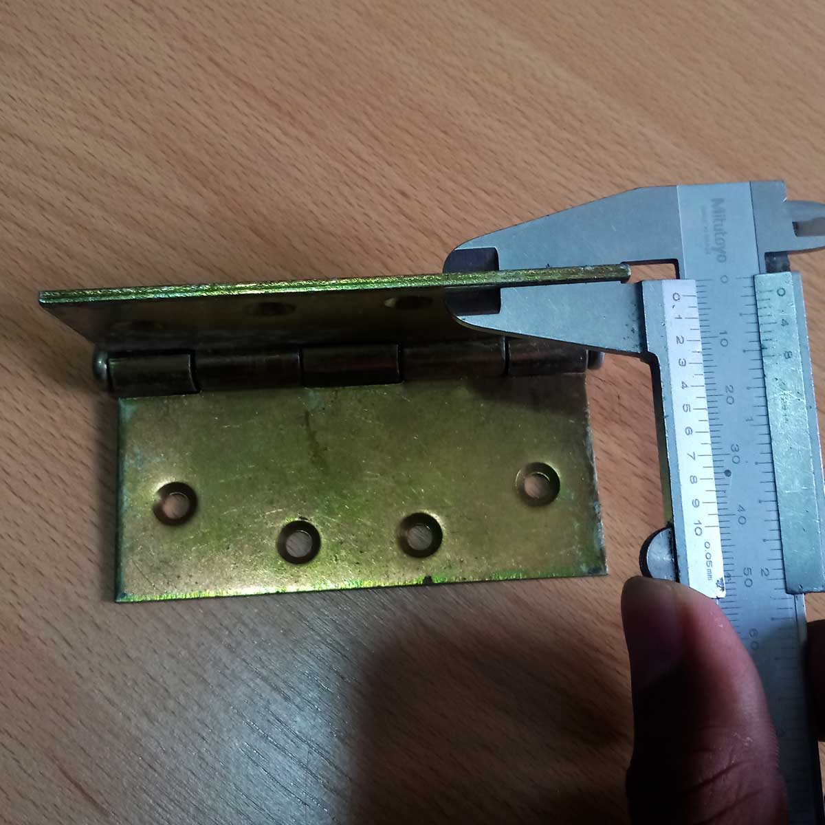 Bisagra de hierro 4x4 color dorado mostrando 2.75mm de espesor con vernier