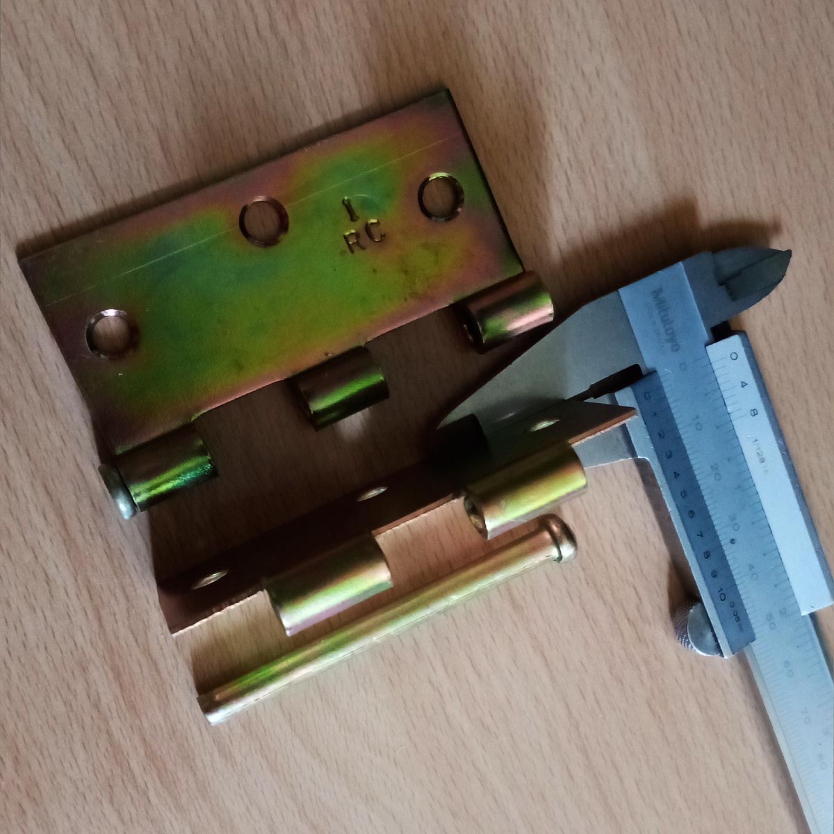 Bisagra 3x3 color dorado mostrando calibre de la lámina con vernier