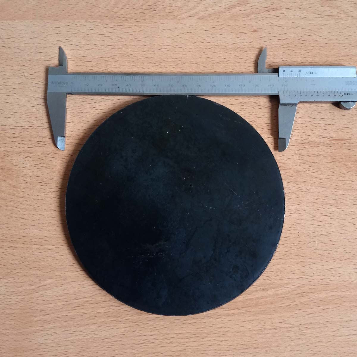 Se muestra en la imagen la medida (diámetro) con vernier de la base de hierro redonda 15x6mm sin huecos.