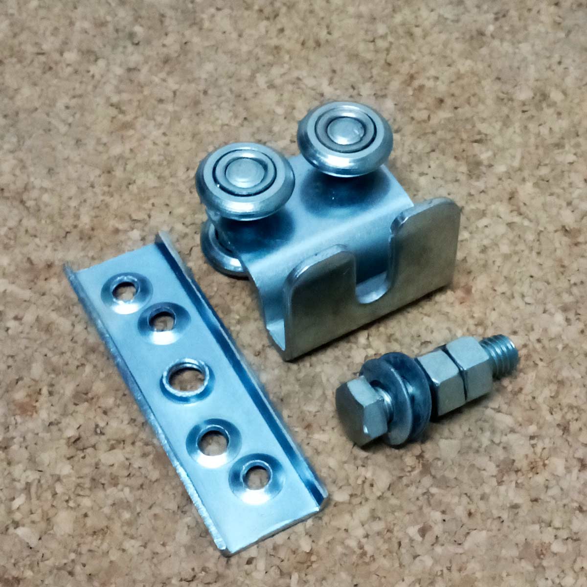 Garrucha R25 Doble con su herraje y tornillo en fondo de madera clara