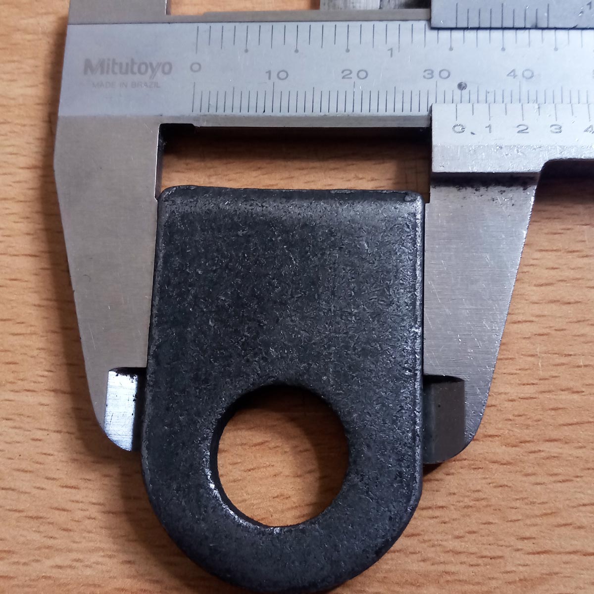 Foto técnica que muestra el ancho total de 32.5  mm aproximadamente en la oreja para candado de 6mm para soldar.