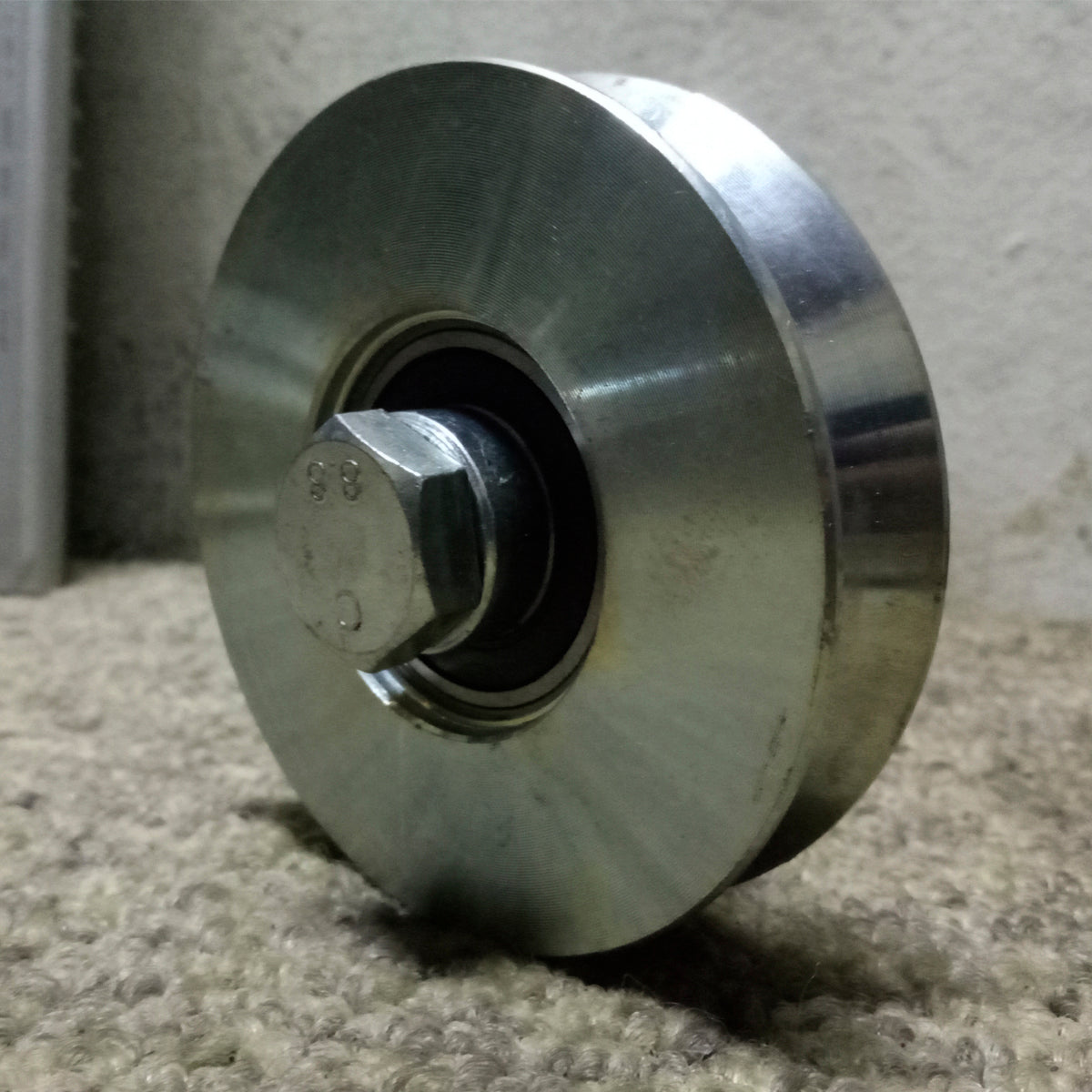 Vista angular de la roldana de 4 pulgadas con su tornillo y rolinera.